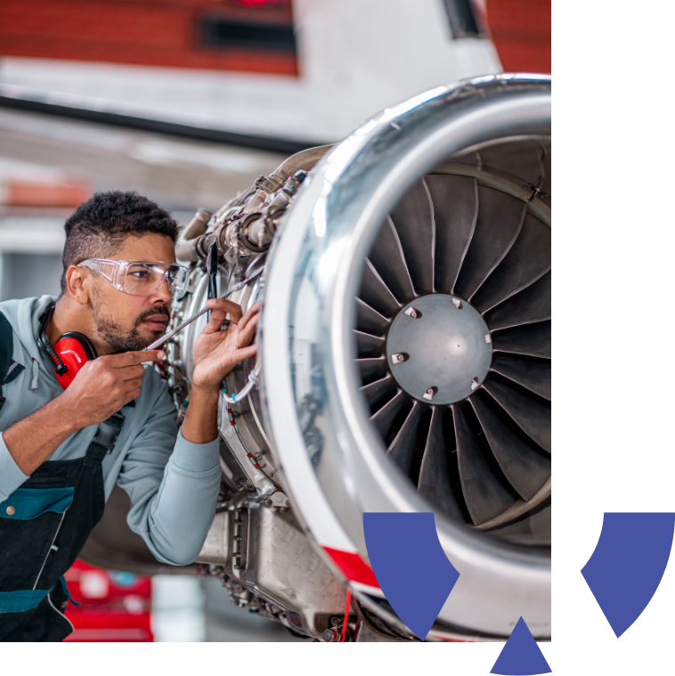 Aircraft Maintenance Mechanic Inspecting and Working on Airplane Jet Engine in the Hangar