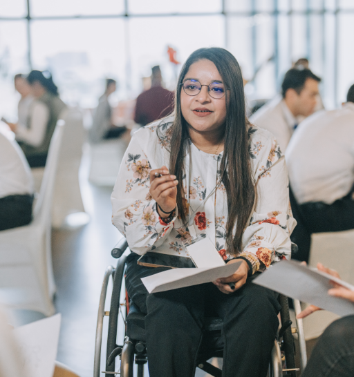 Asian Indian disabled woman in wheelchair participate in business conference workshop leading discussion