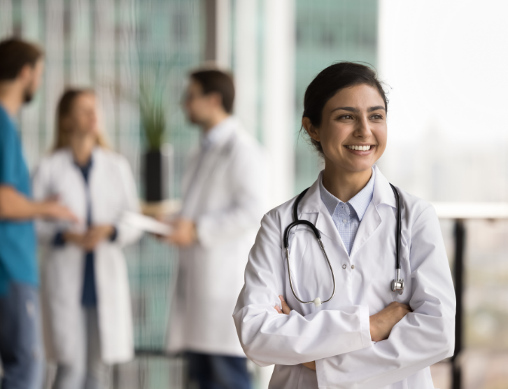 Indian doctor woman in white uniform with stethoscope posing in clinic hall