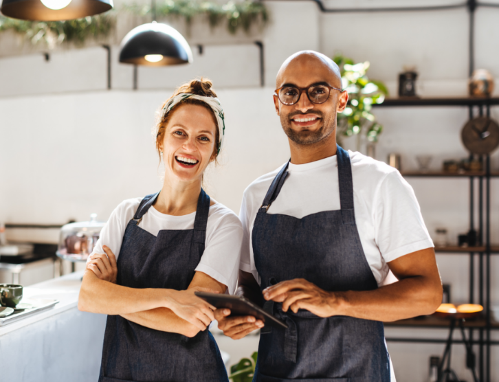 Two hospitality entrepreneurs standing confidently in their small coffee shop